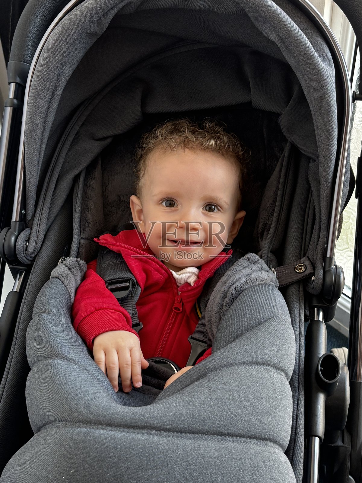 一个可爱的小男孩在婴儿车里享受户外时光照片摄影图片