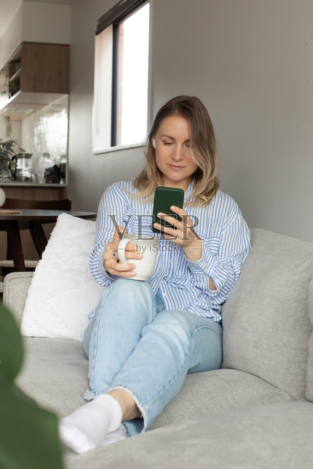 女人一边喝着咖啡，一边用智能手机浏览互联网照片摄影图片