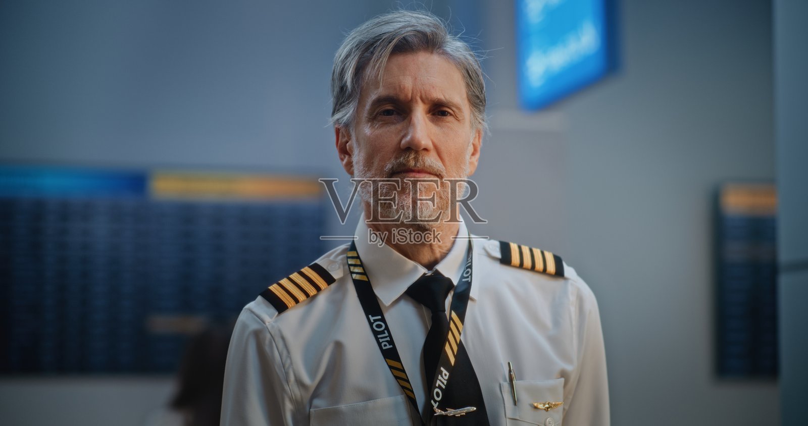 拥挤的国际机场航站楼：职业航空飞行员的肖像照片摄影图片