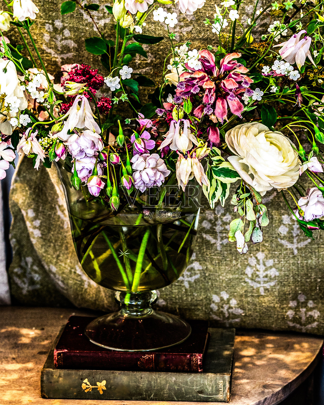 复古书籍上的玻璃花瓶里的花朵照片摄影图片