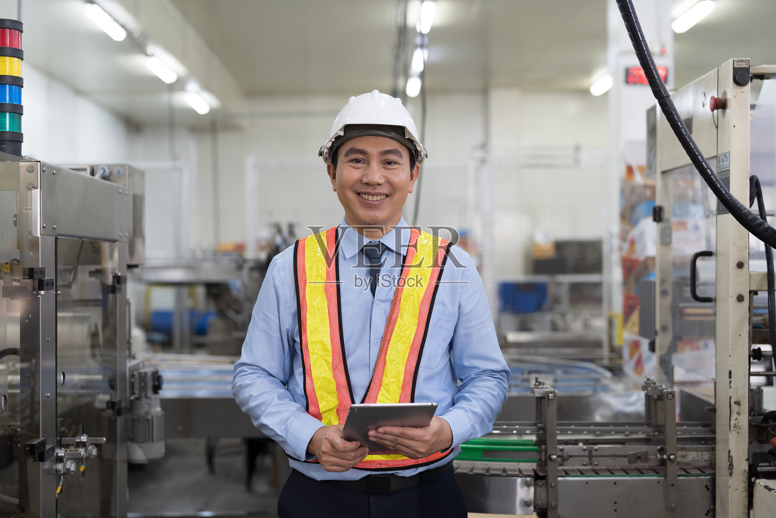男性工程师，工业工厂，储存仓库。亚洲男性工厂工程师正在使用数字平板电脑控制或检查工业工厂的生产系统操作。照片摄影图片