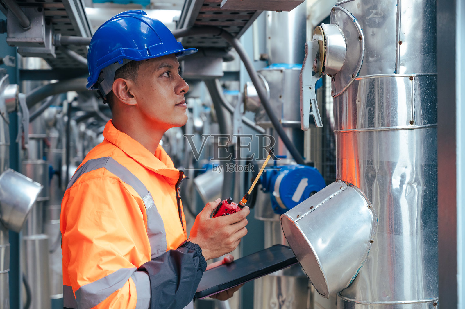 技术人员在施工项目中仔细检查一段管道，强调基础设施开发中的安全和精确。照片摄影图片