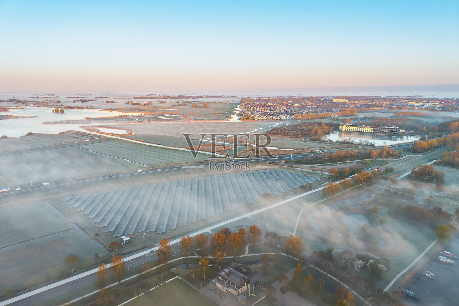 高速公路旁的太阳能电池板，晨曦中的荷兰雾景照片摄影图片