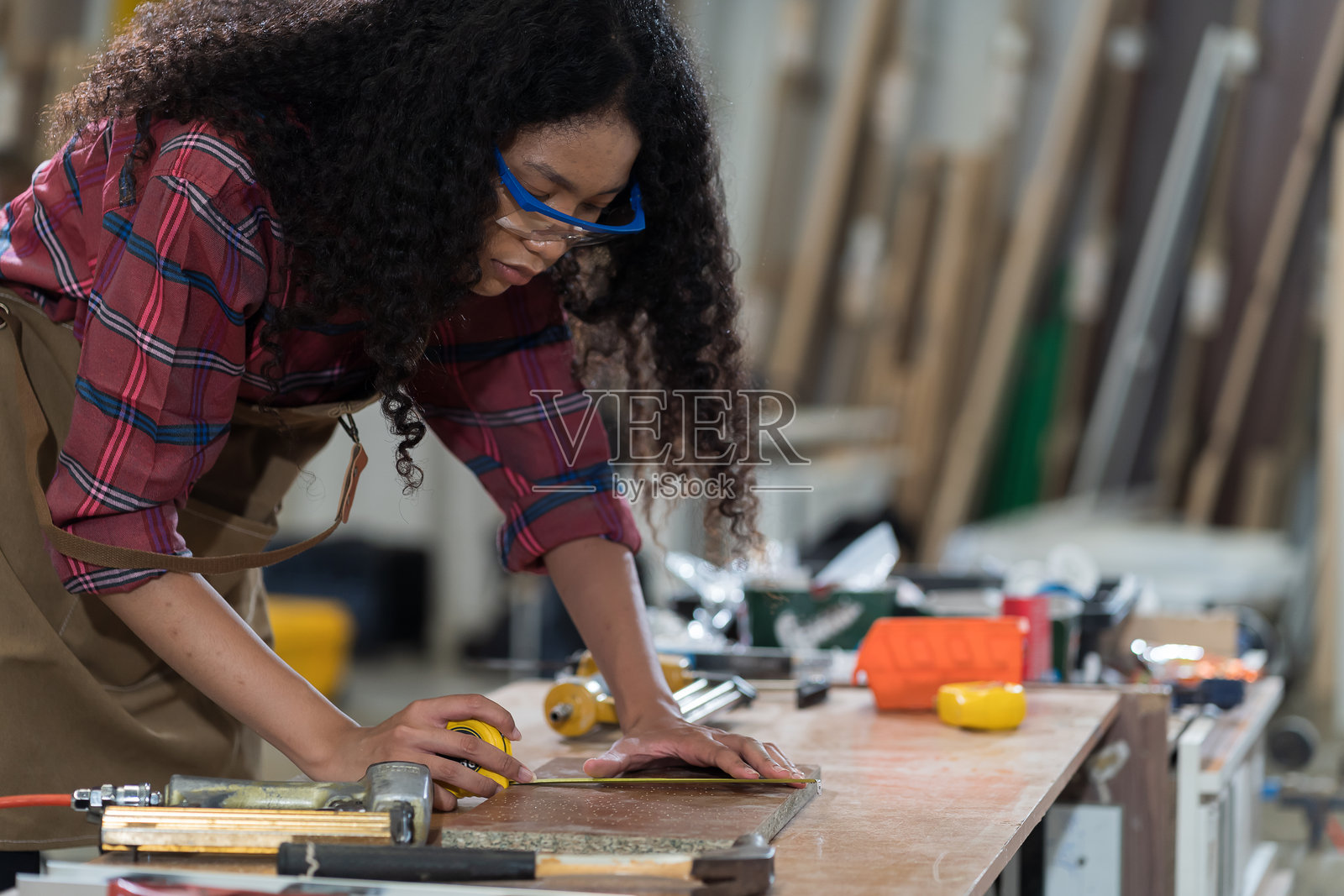 胶合板加工厂。家具制造。非裔美国工人在家具厂使用木工工具。照片摄影图片