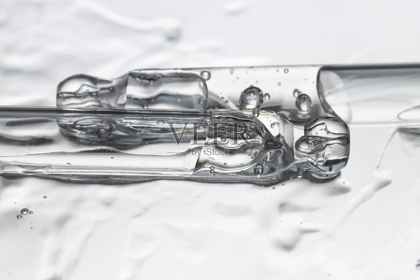 几支玻璃滴管与精华液，液体凝胶在灰色背景下，特写前视图。照片摄影图片