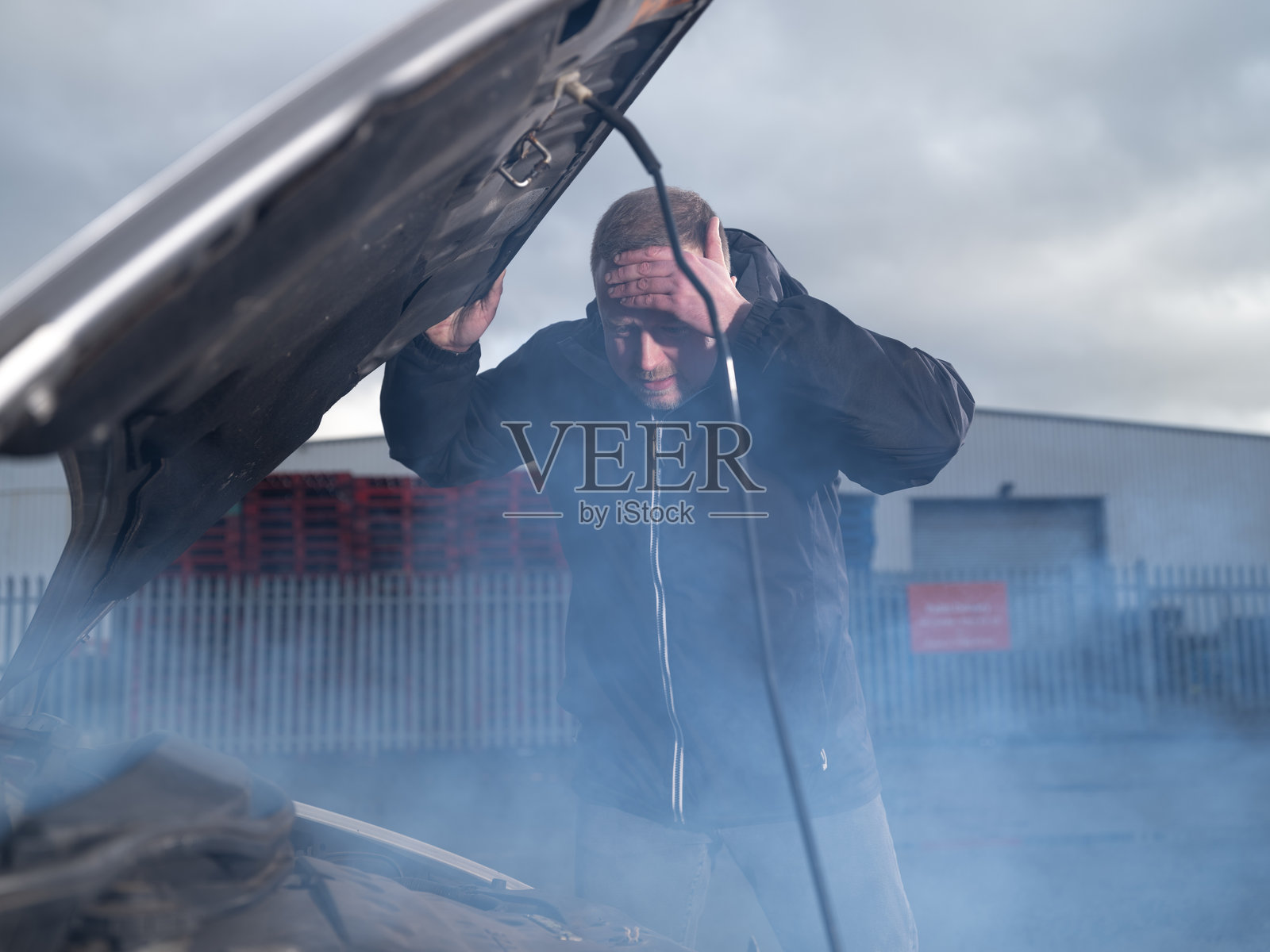 成年男子在故障汽车前焦急地检查发动机舱照片摄影图片