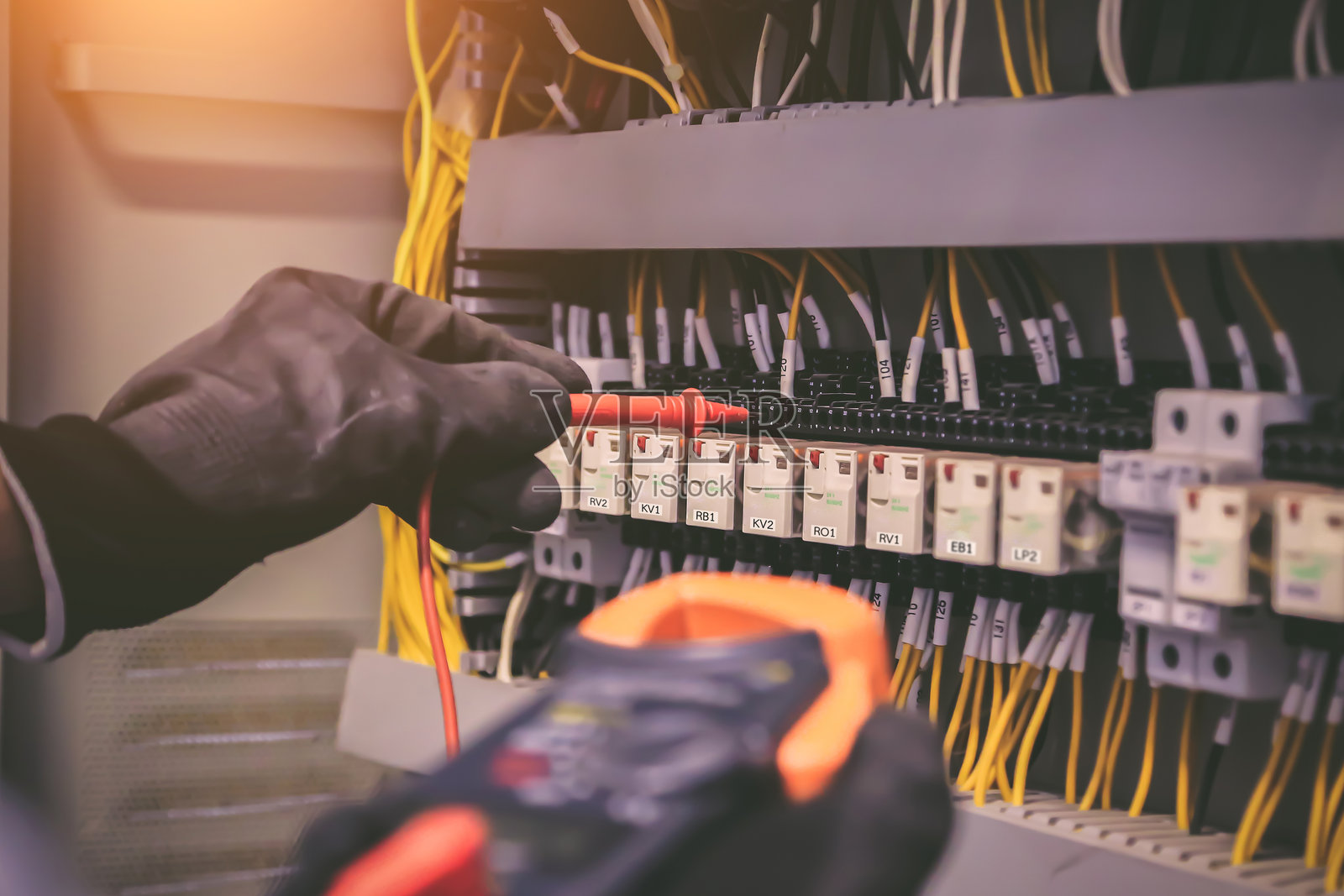 电力和电气维护服务，工程师使用仪表检查电路断路器和电缆布线系统的接线端子，以修理主电力配电板。照片摄影图片