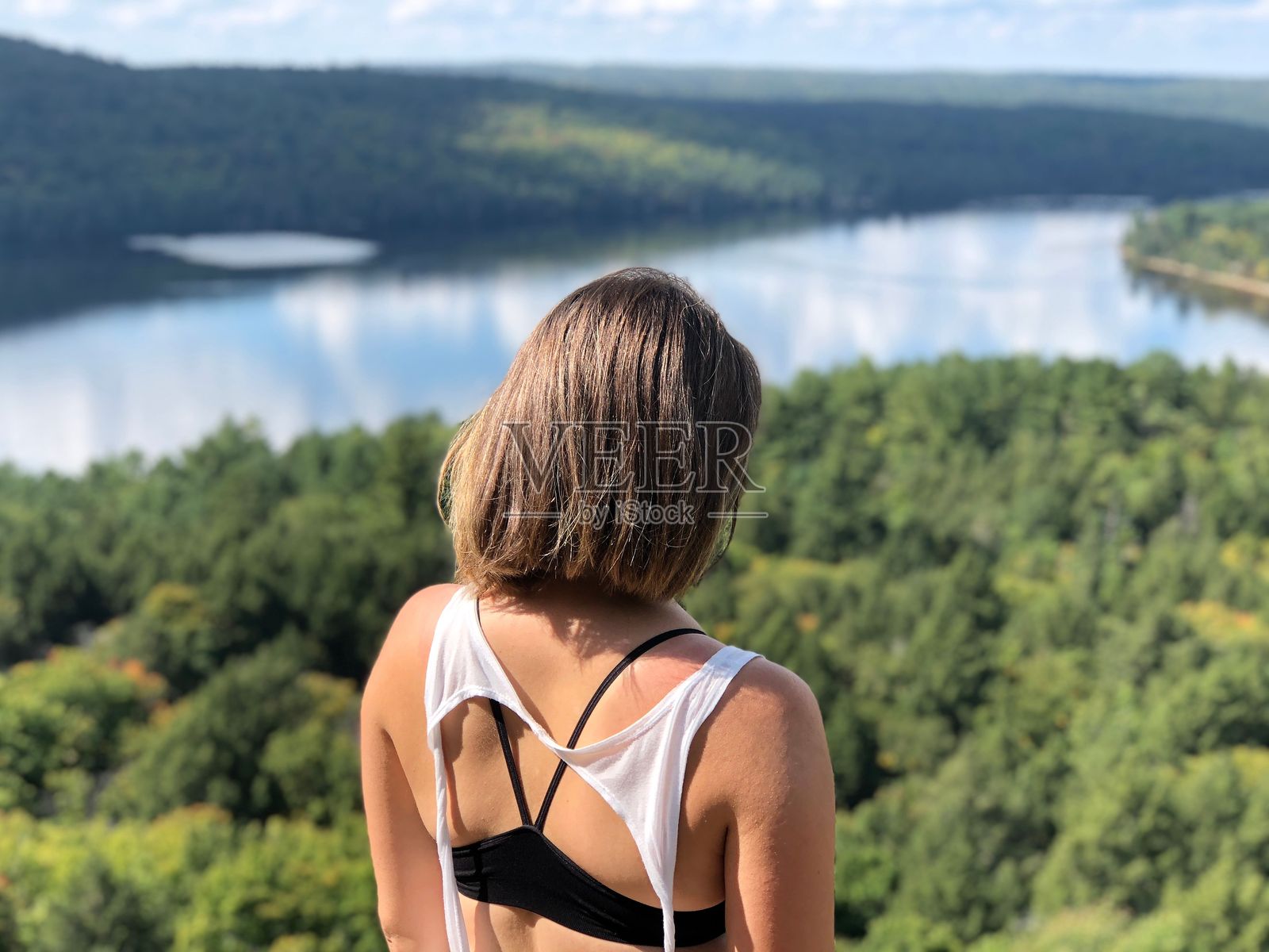 女人俯瞰风景如画的森林和湖泊照片摄影图片