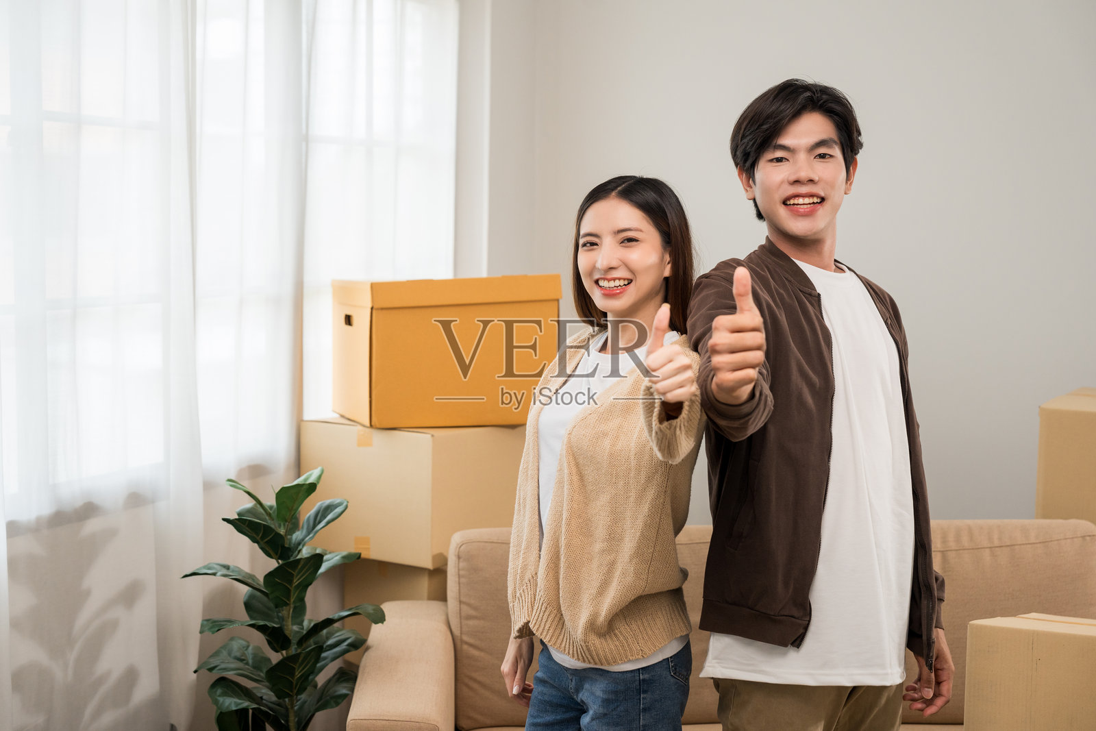 亚洲家庭夫妇购买新房。快乐的时刻，男女正在搬入新家，搬运包裹并进行装饰，搬家时有很多纸箱。照片摄影图片