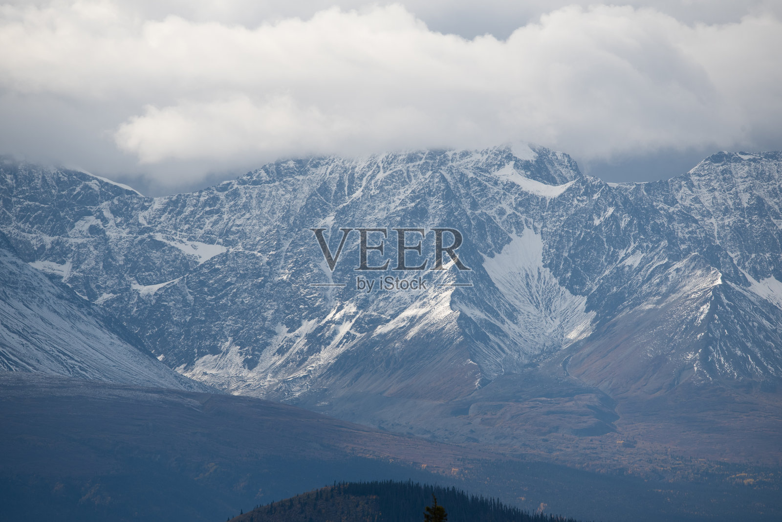 阴郁多云的日子里，山顶拍摄的雪水顺着山脉流下。位于育空地区的海恩斯交汇处。照片摄影图片