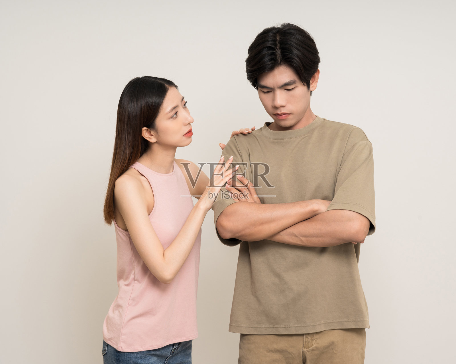 不幸的亚洲情侣在孤立的白色背景上争吵，表现出各种动作和手势。愤怒的男人和女人大声喊叫，感到压力，婚姻生活中存在问题。照片摄影图片