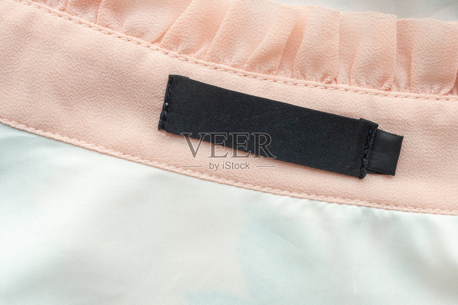 黑色空白洗涤标签在衬衫面料纹理背景上照片摄影图片