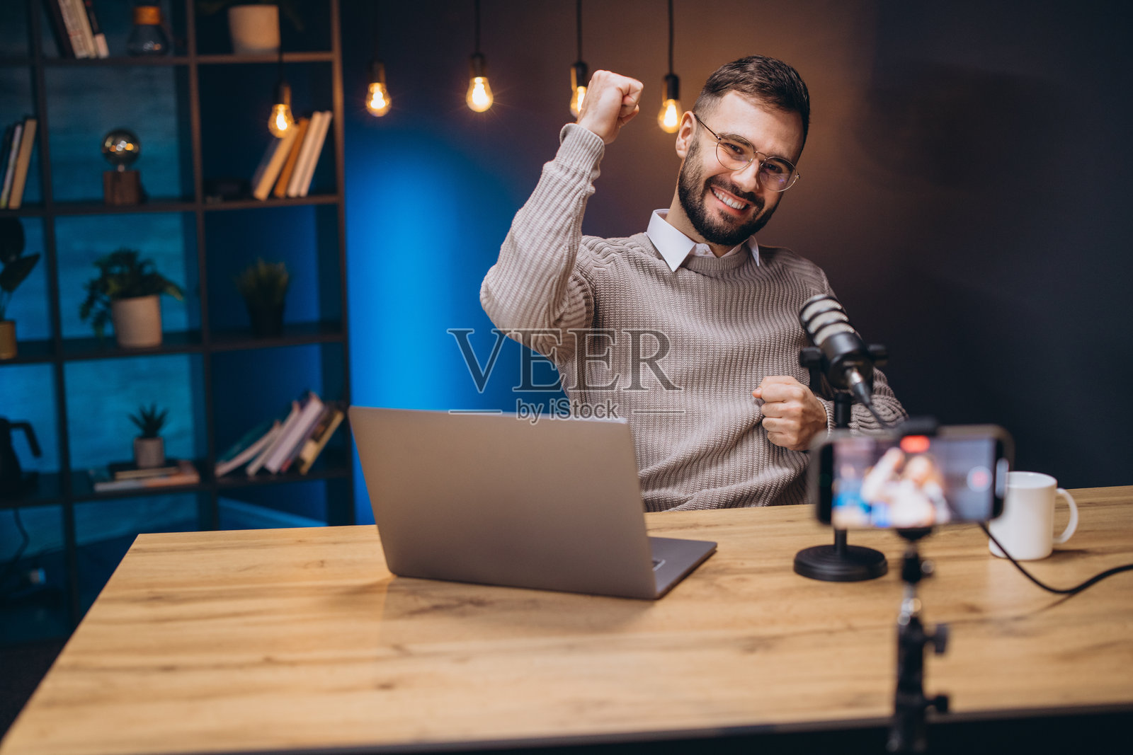 快乐的播客主持人在专业录音室中庆祝成功并录制新一集节目照片摄影图片