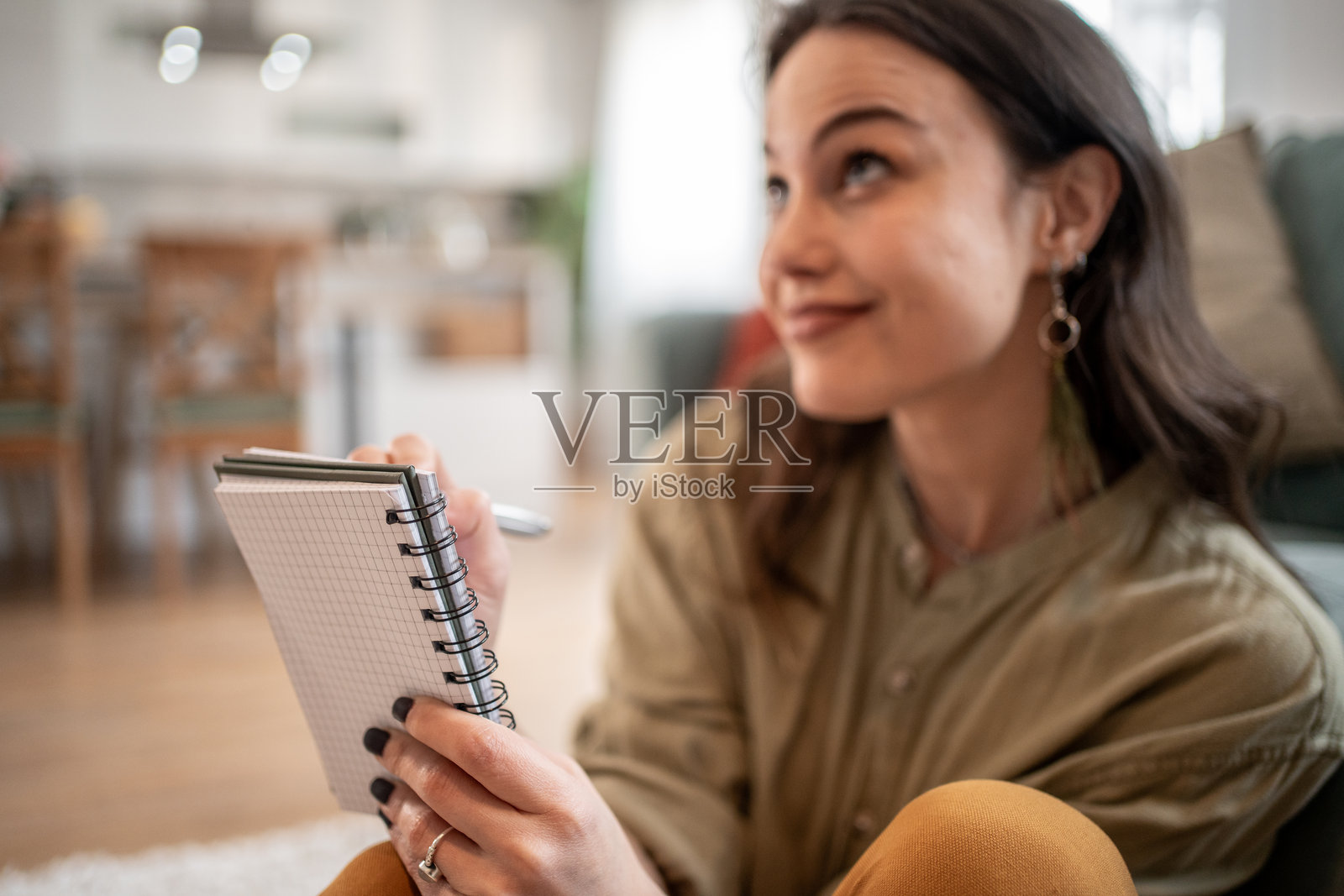 年轻女性在家办公室里认真做笔记并思考照片摄影图片