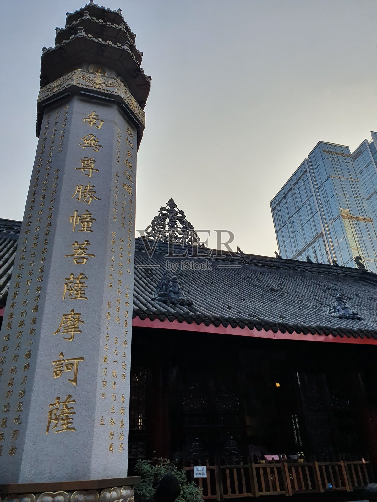 传统中国寺庙，精美的木雕，弯曲的屋顶，金色的书法匾额，映衬在晴朗的蓝天之下。照片摄影图片