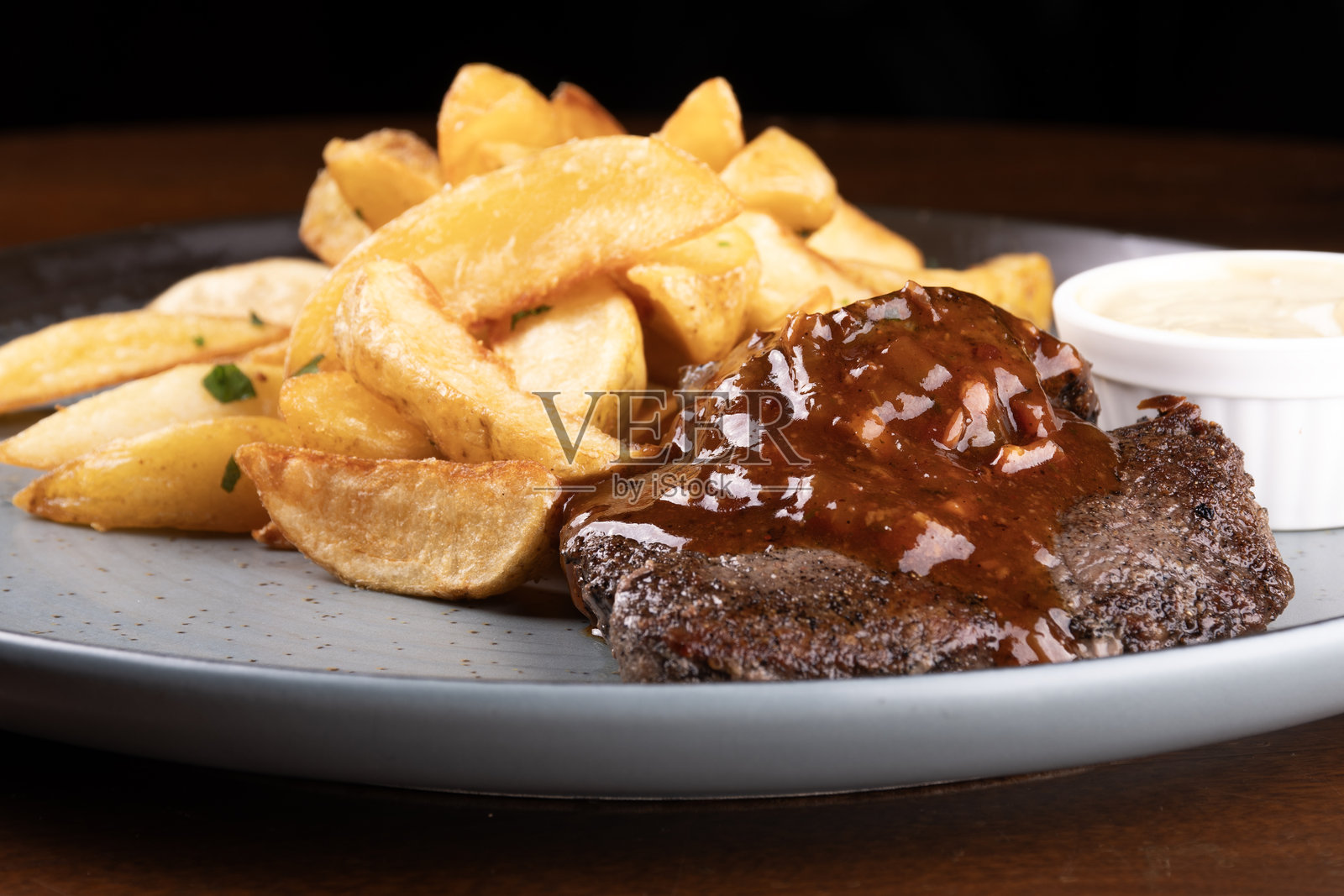 美味的牛肉菲力菜肴，配有烧烤红酒酱和乡村土豆特写照片摄影图片