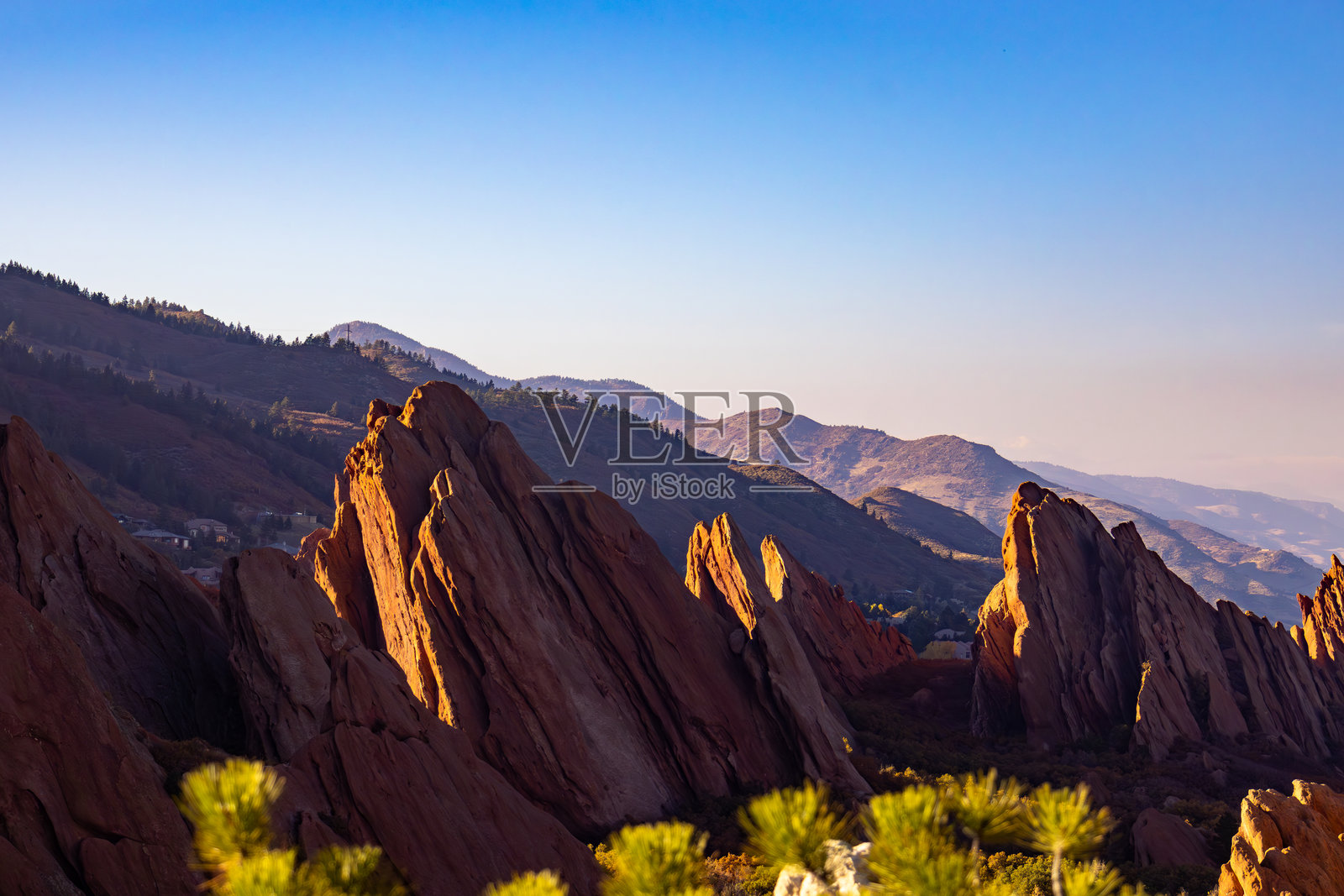 在黄昏时分，山脉景观中的崎岖岩石在日落的照耀下显得格外迷人。照片摄影图片