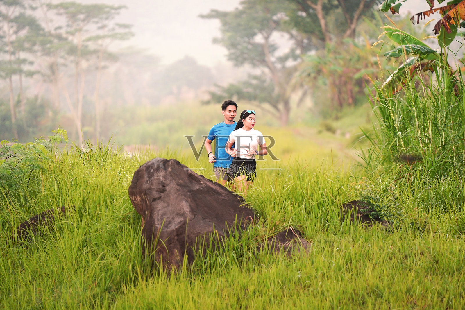 年轻的亚洲情侣在绿色乡村地区慢跑和锻炼照片摄影图片