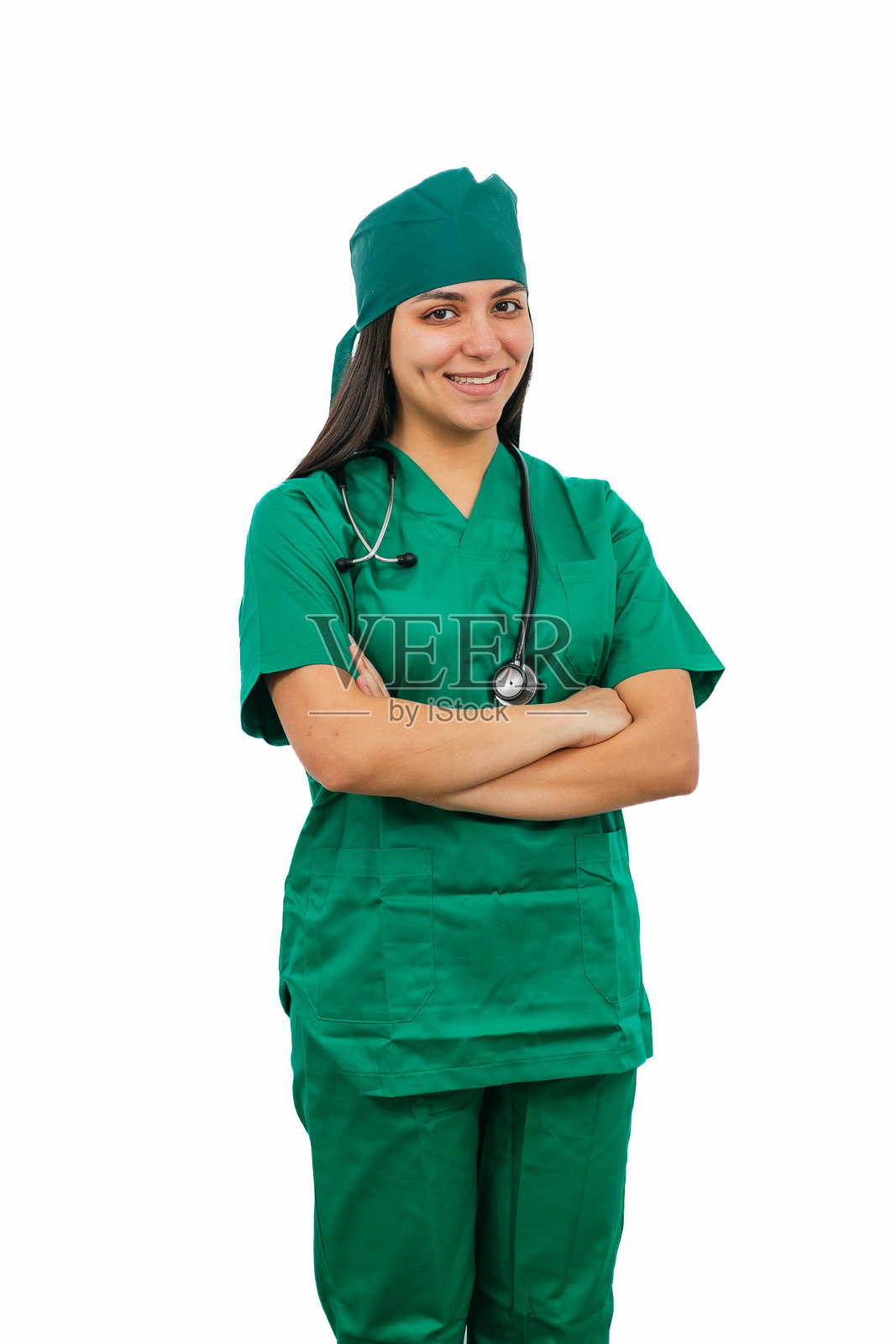 年轻的拉丁裔女性外科医生微笑着，双臂交叉，背景为白色。照片摄影图片