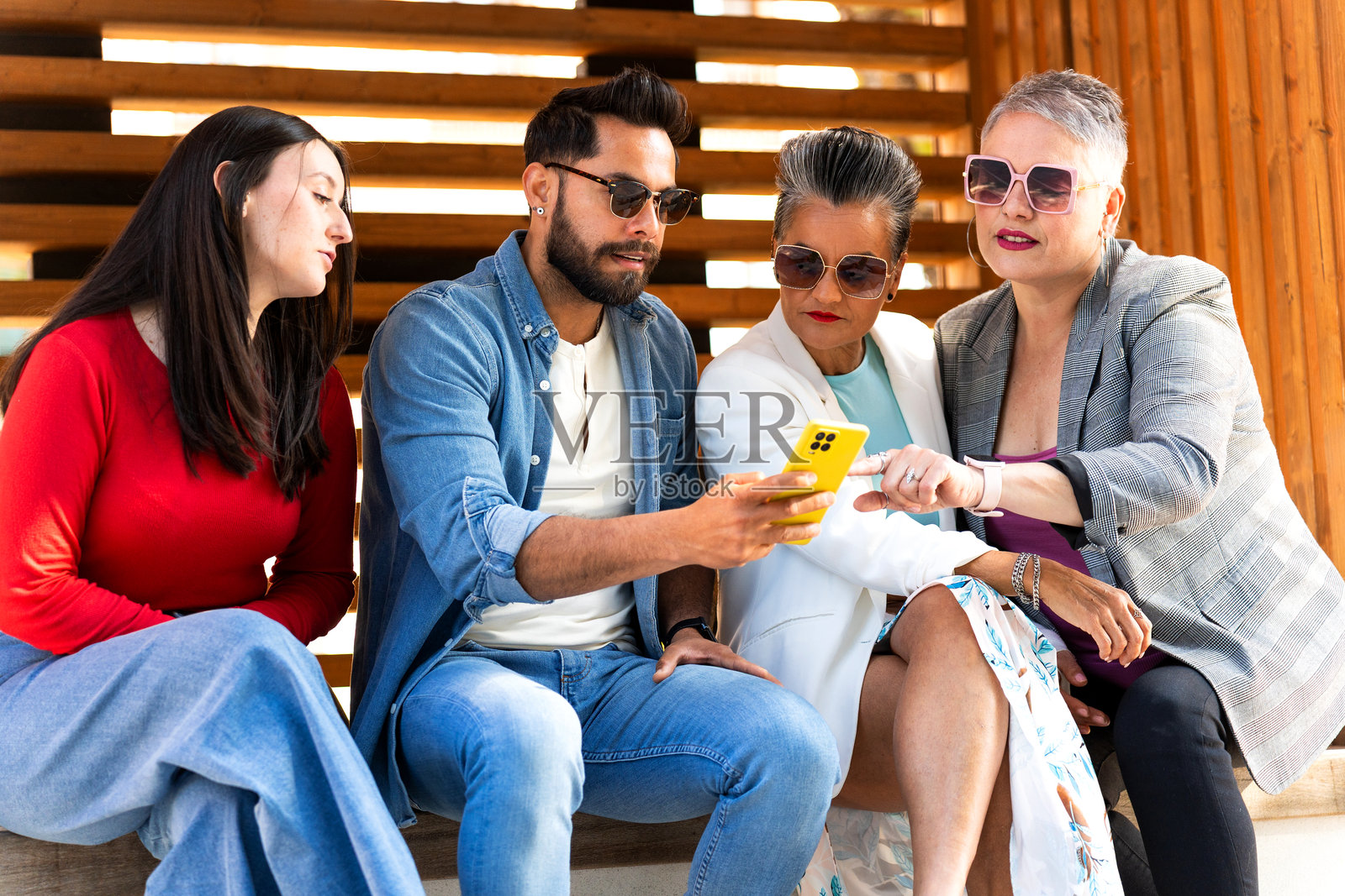 一群多元化的人在户外使用智能手机照片摄影图片