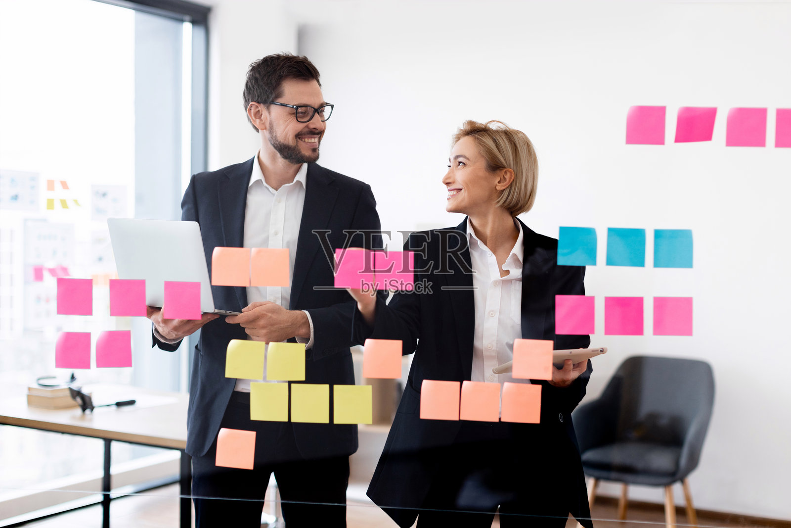 专业人士在玻璃墙上使用便利贴进行共同规划照片摄影图片