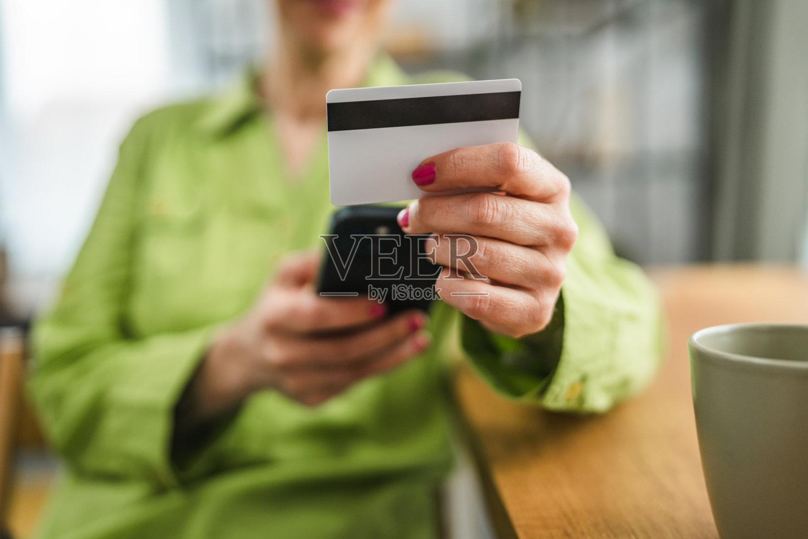 特写镜头：女性手持手机和信用卡进行购物照片摄影图片