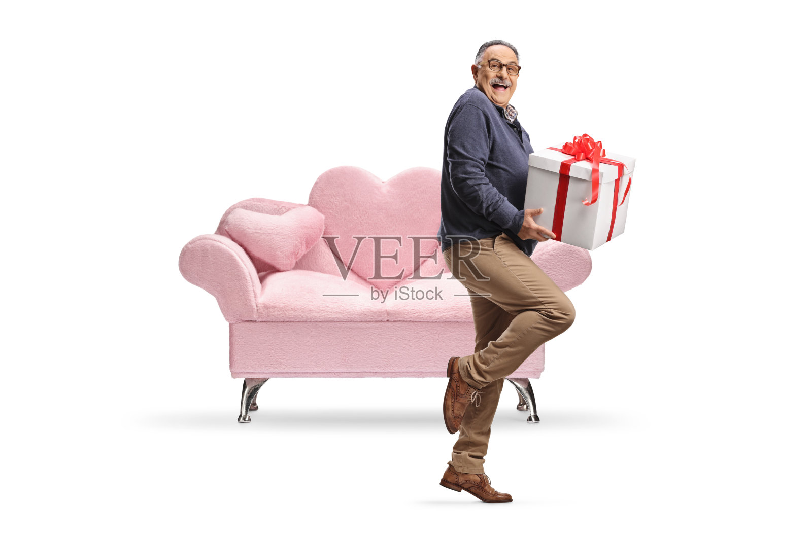 兴奋的成熟男人在粉色沙发前拿着一个礼品盒照片摄影图片