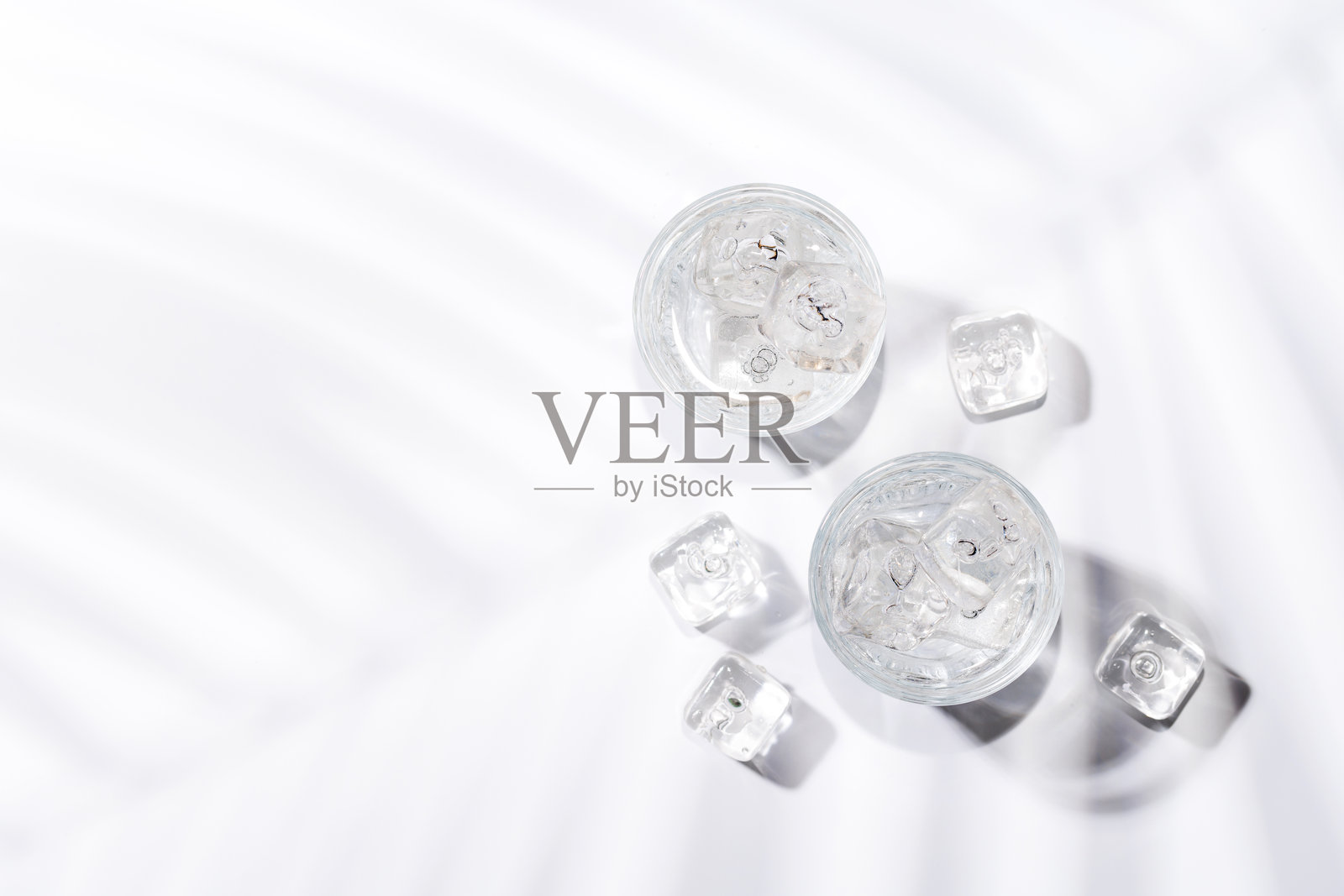 装满冰块和冷水的晶莹剔透的玻璃杯照片摄影图片