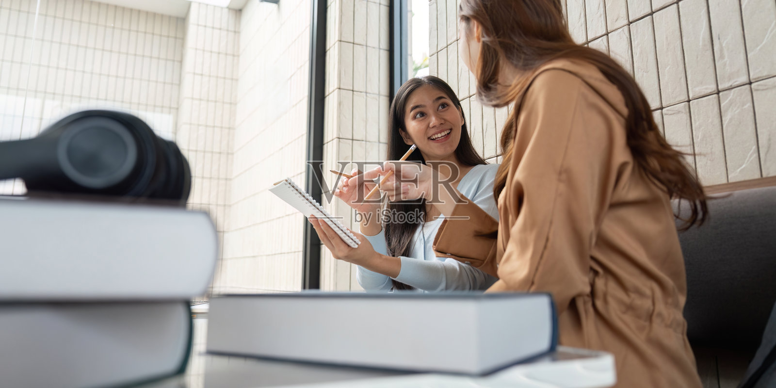学习伙伴互动。专注的学生在学习桌前有效合作，分享见解。照片摄影图片