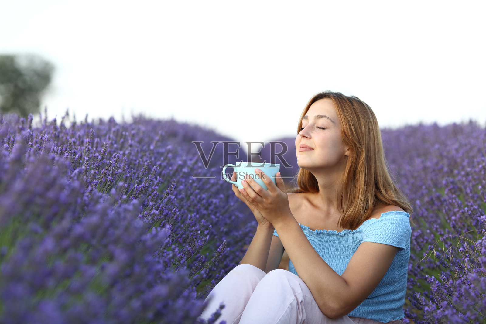 在薰衣草田里喝咖啡并深呼吸的女人照片摄影图片