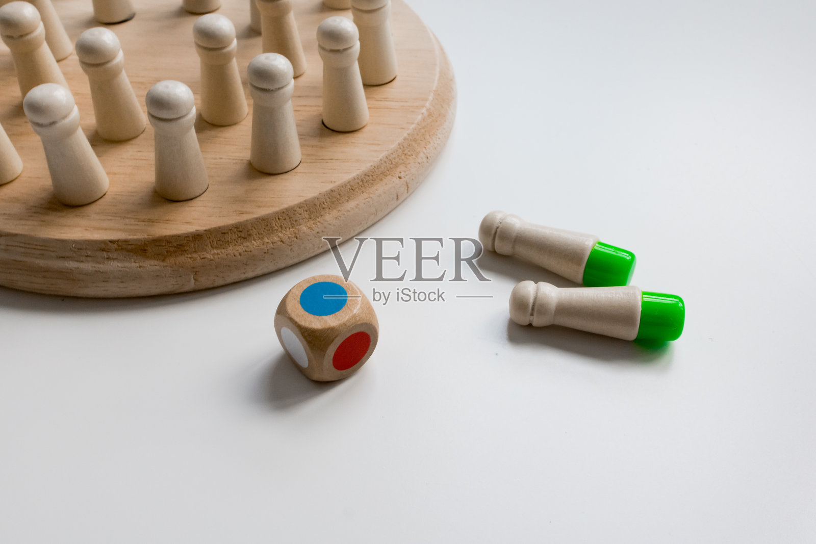 白色表面上的木制棋盘游戏，配有五颜六色的骰子和棋子照片摄影图片