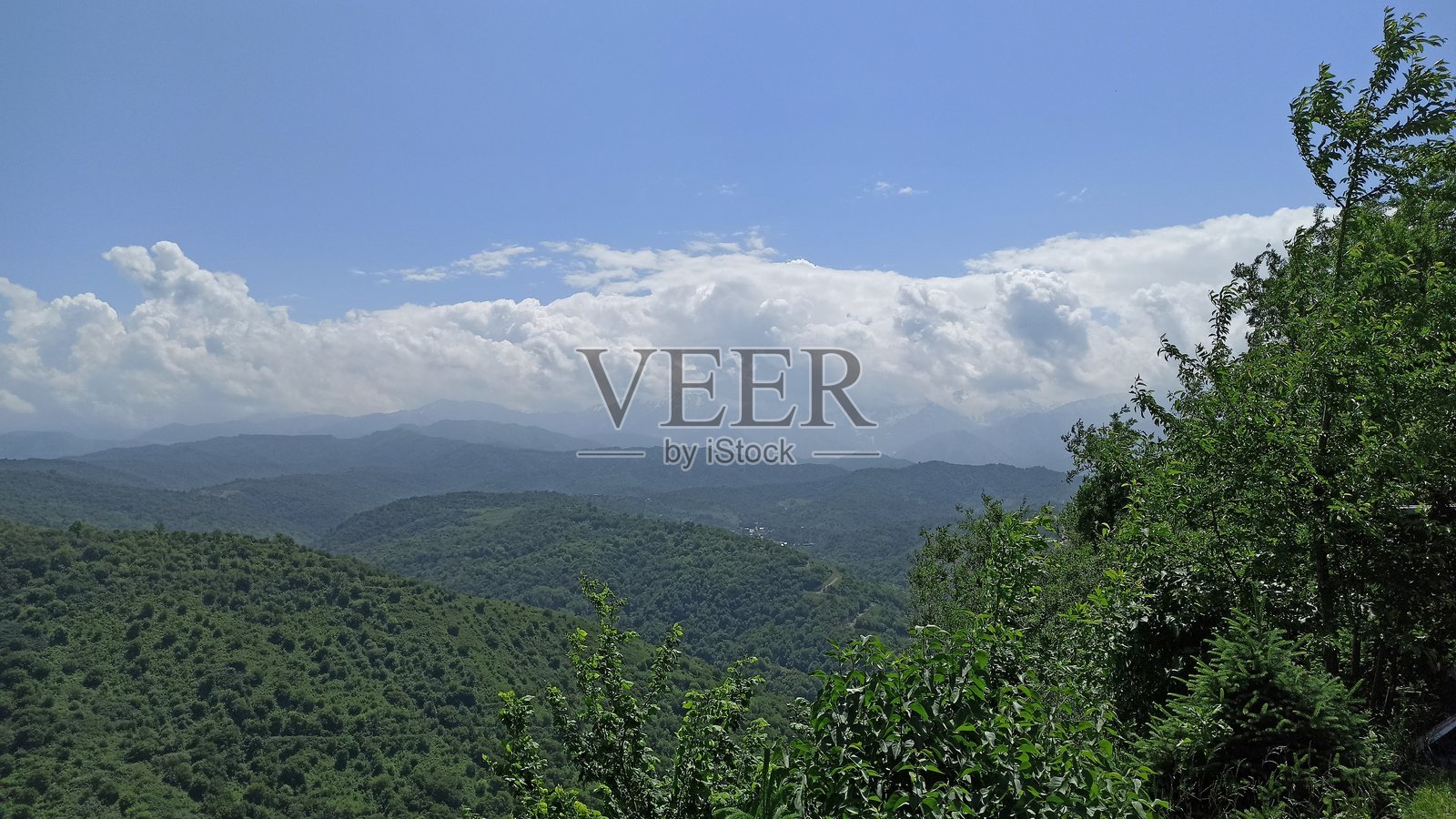 从阿拉木图的一座山丘上俯瞰山脉，背景中可见云朵。照片摄影图片