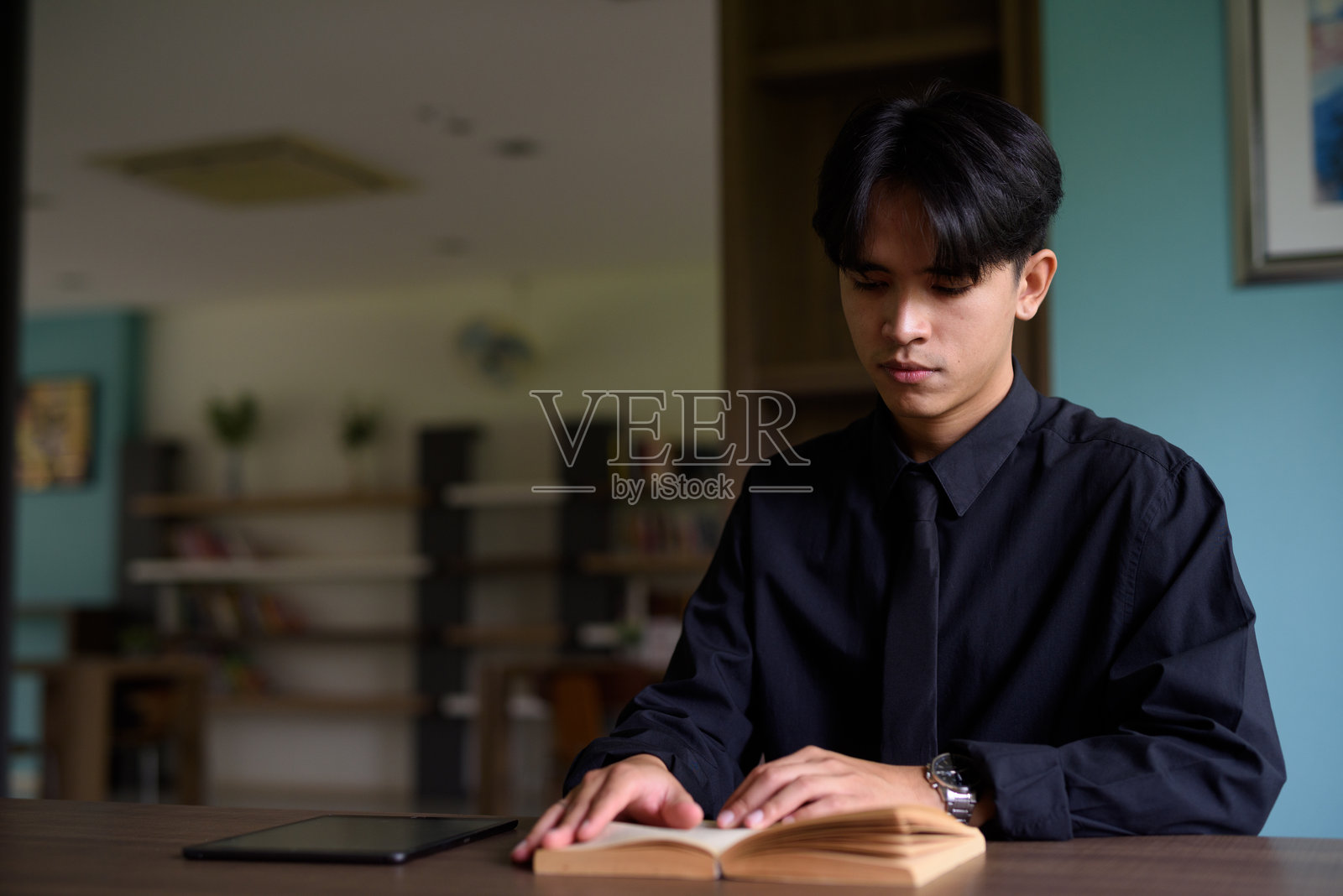 年轻亚洲男子在图书馆阅读书籍的肖像照片摄影图片