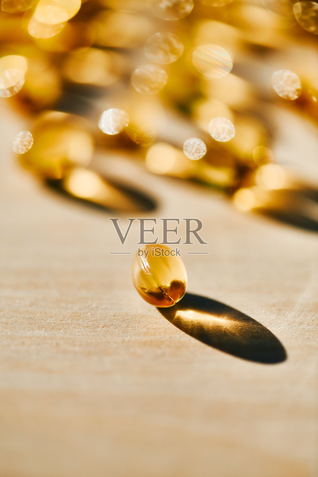 温暖阳光下的金色软胶囊照片摄影图片