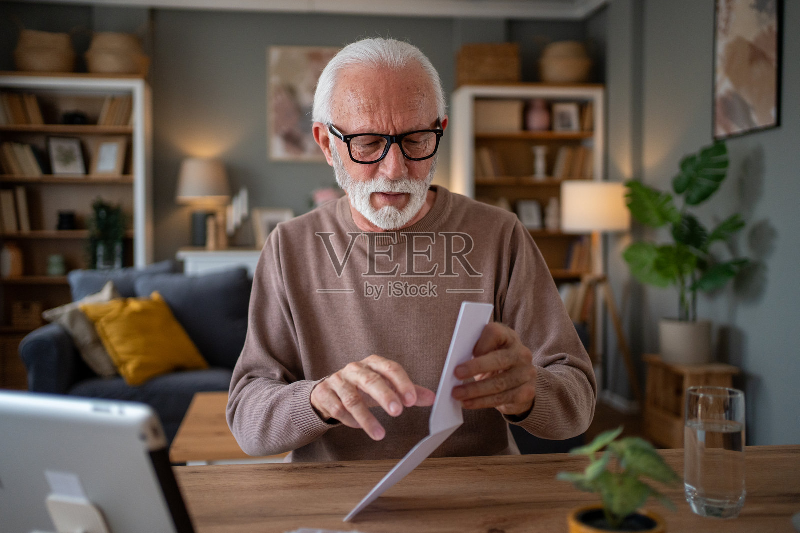 老年人在家中打开邮件，手里拿着平板电脑照片摄影图片