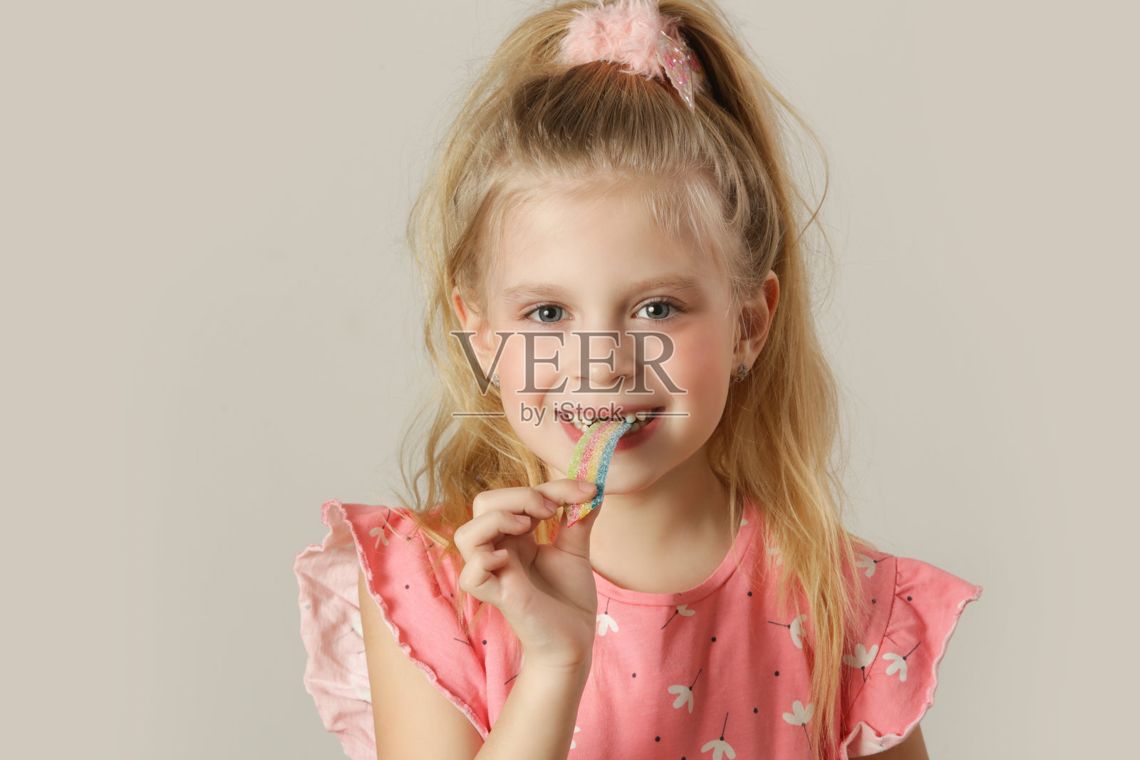 可爱的小女孩在吃五彩缤纷的酸甜糖条照片摄影图片