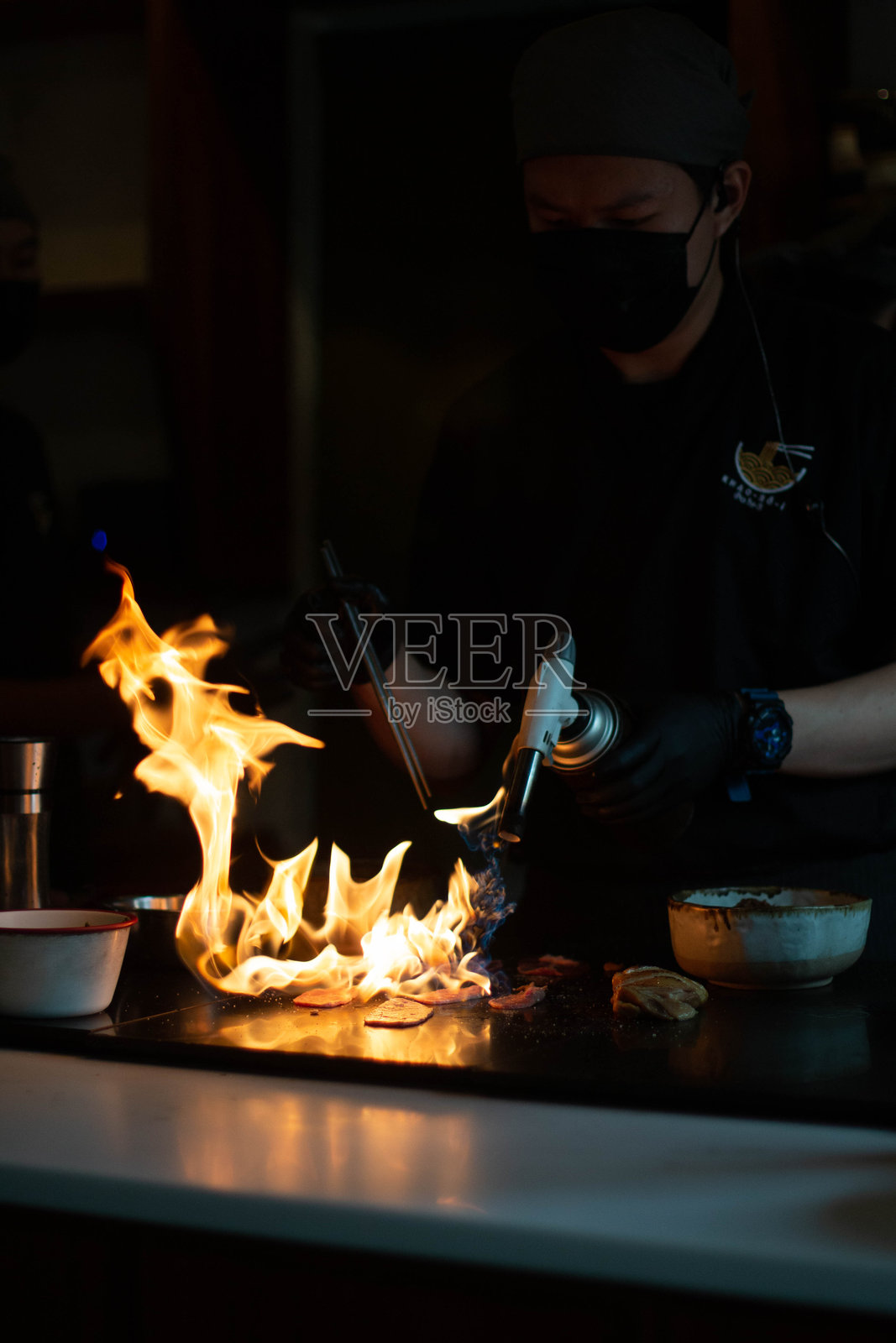 厨师用火炬烤肉，火焰四射照片摄影图片