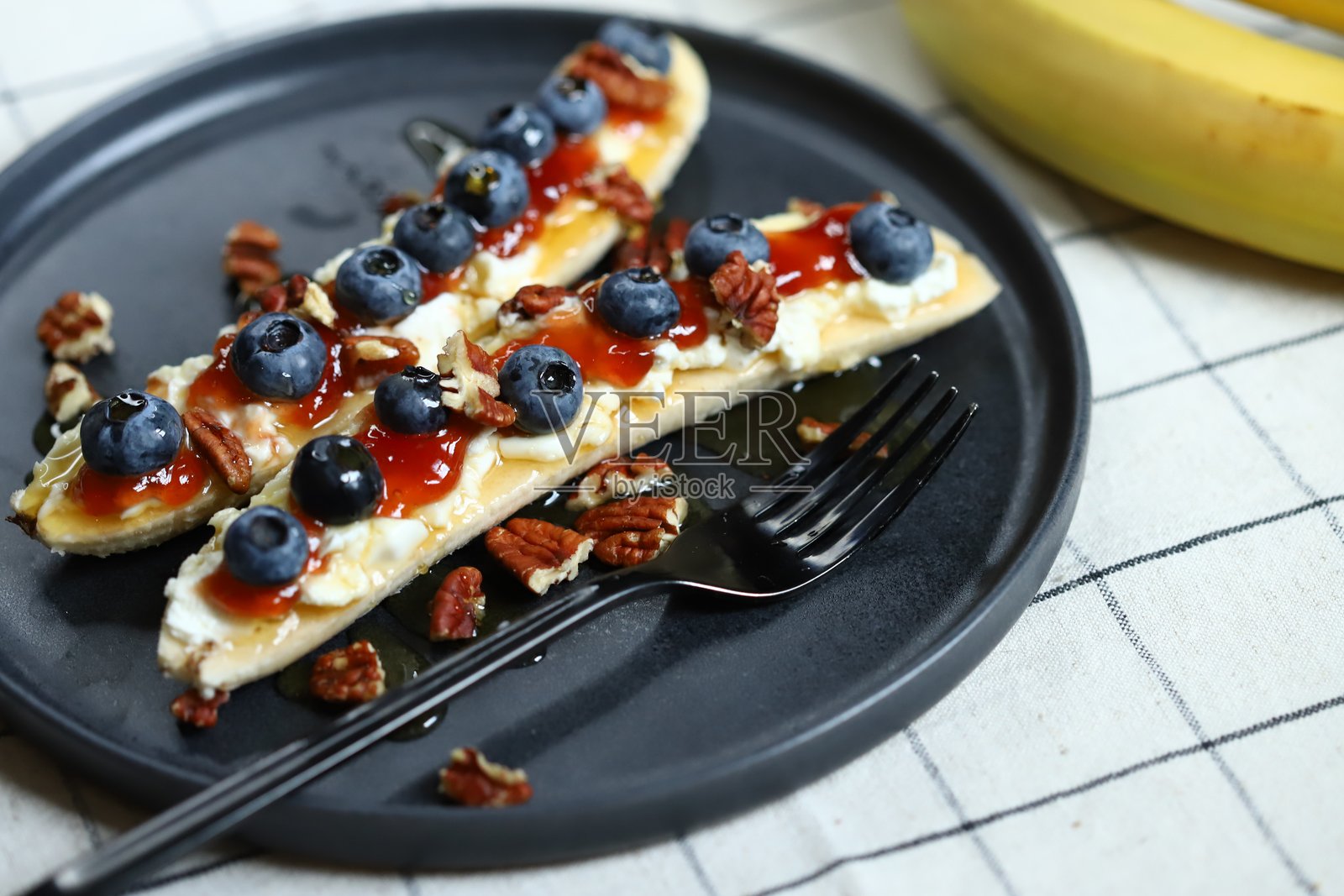 香蕉半片、奶油奶酪和蓝莓。照片摄影图片