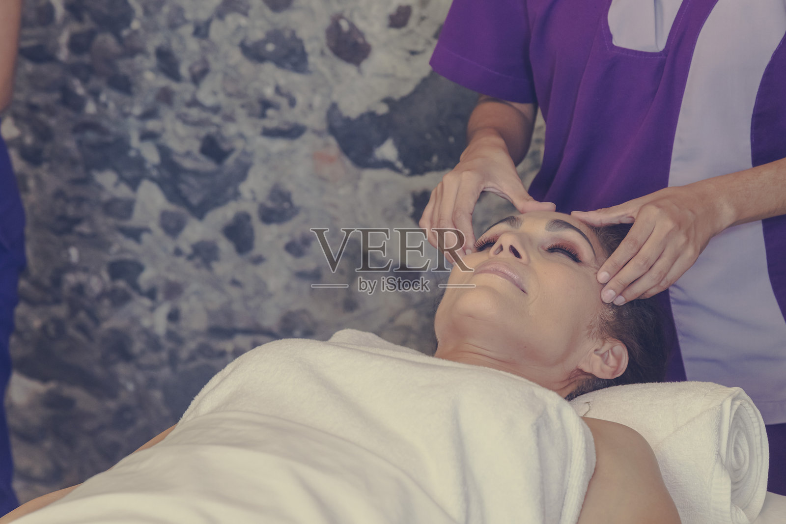 按摩师在水疗中心为客户提供放松的头部按摩照片摄影图片