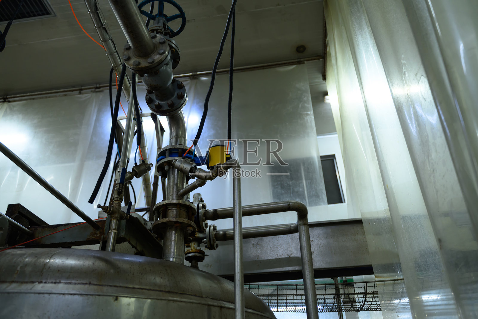 工厂中工业级不锈钢罐和阀门组件的特写视图照片摄影图片