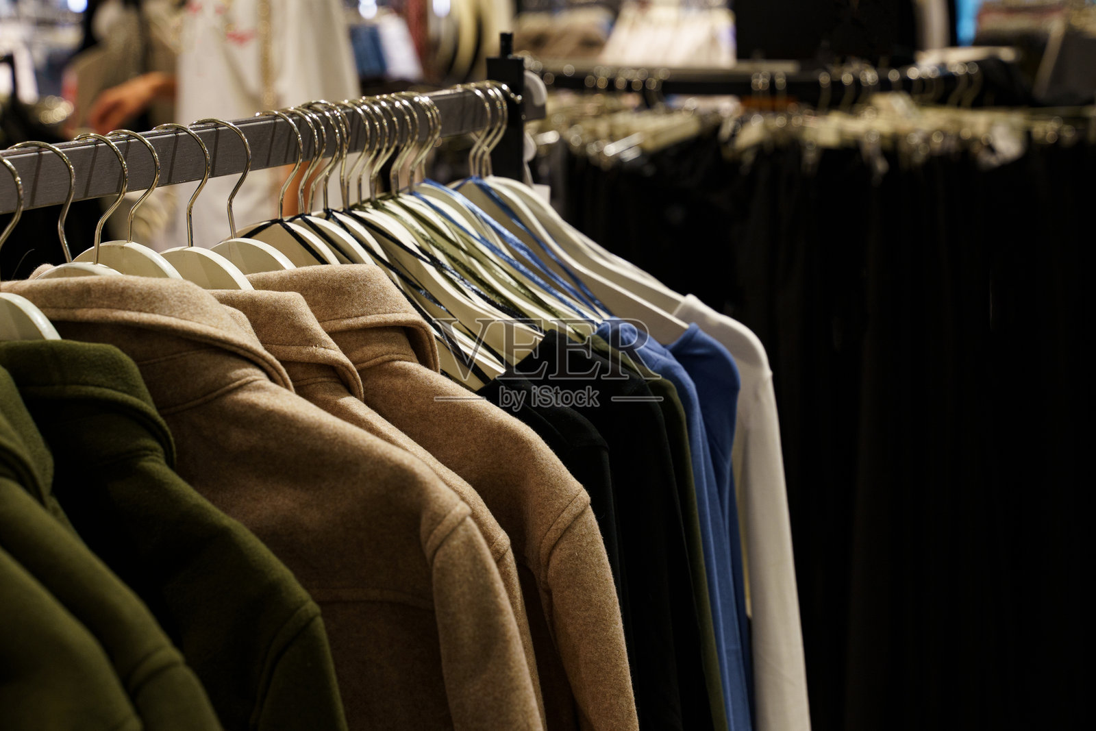 时尚零售店中整齐悬挂的服装系列照片摄影图片