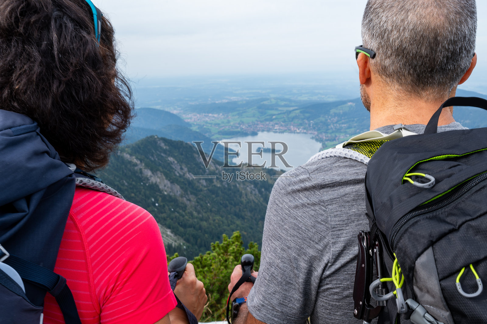 从后面特写一对登山者情侣欣赏山湖全景照片摄影图片