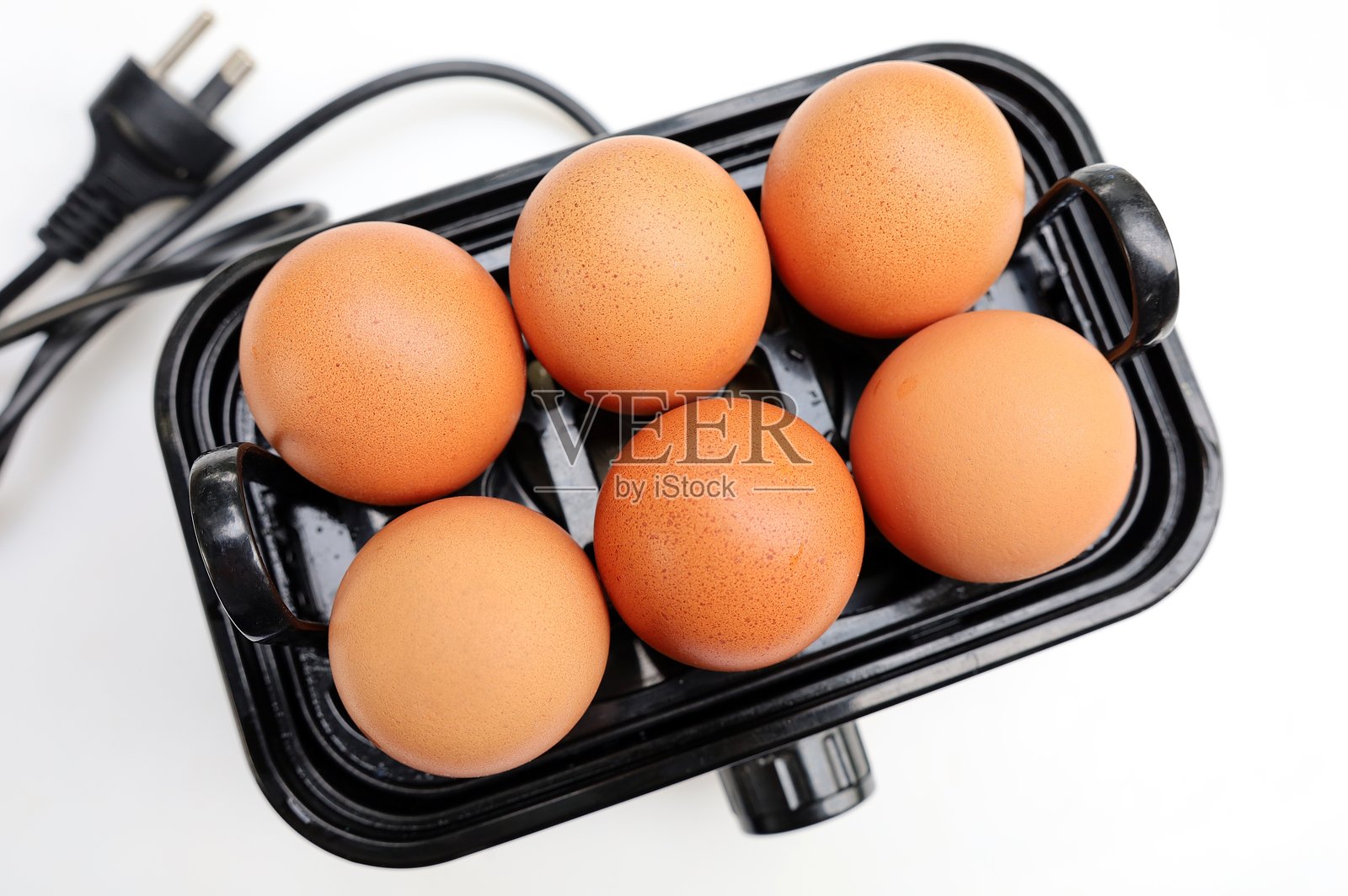 蛋在煮蛋器上。照片摄影图片