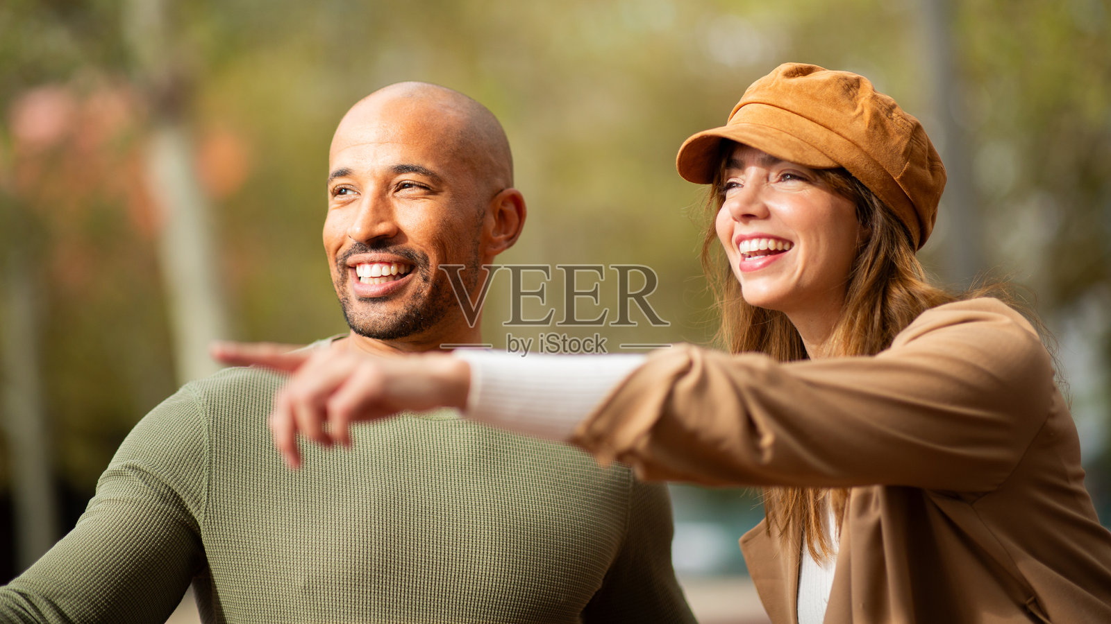 一对情侣在指着远处的某样东西时分享欢笑照片摄影图片