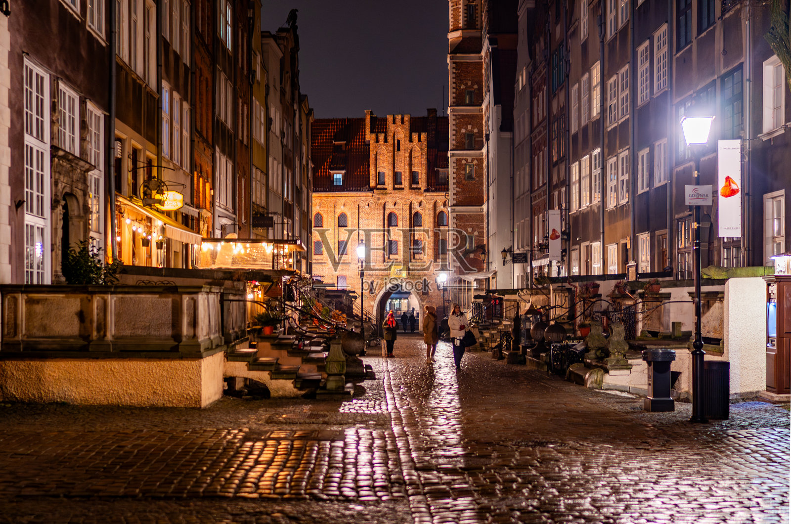 格但斯克老城玛利亚卡街的夜景,灯光照亮的建筑和湿润的人行道照片摄影图片