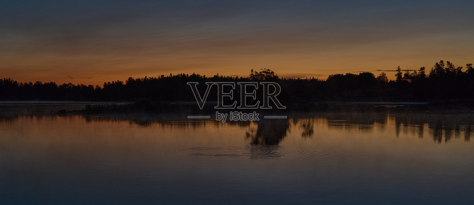 仲夏凌晨3点，斯德哥尔摩群岛的Graso。即使太阳已经落下，天色依然明亮。从一个码头俯瞰平静如镜的海湾，尽享整夜的日落美景，视野向右延伸。照片摄影图片