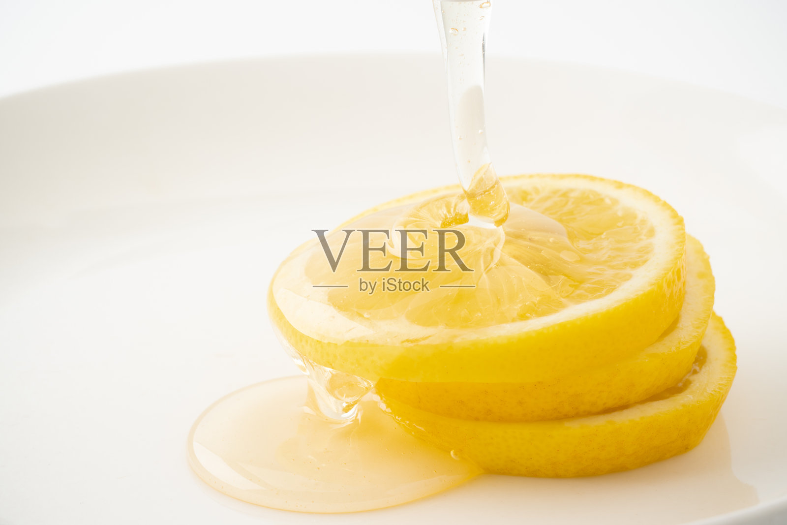柠檬上淋上蜂蜜的特写镜头照片摄影图片