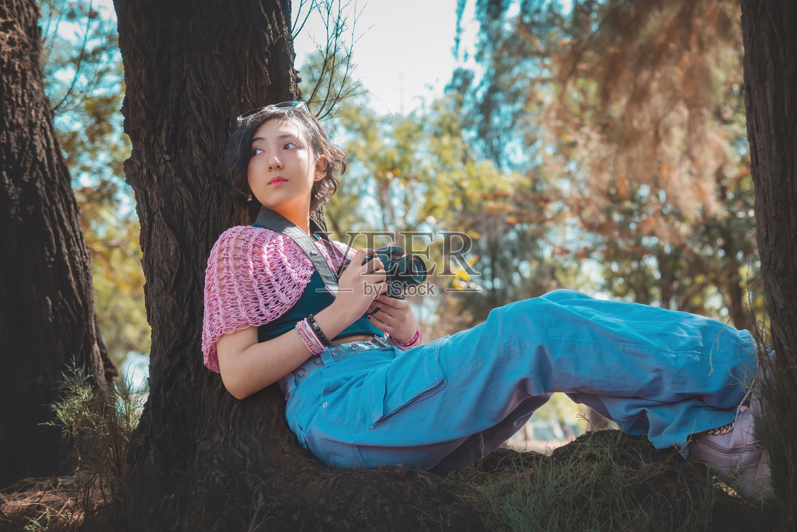 年轻女性摄影师手持相机为镜头摆姿势，摄影师日主题，有充足的空间供书写。照片摄影图片