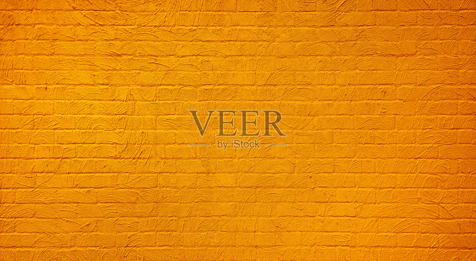 干净的、有纹理的黄色灰泥砖墙为各种设计用途提供了多功能的背景。抽象的风化纹理，污渍斑驳的旧金色灰泥砖墙背景。照片摄影图片