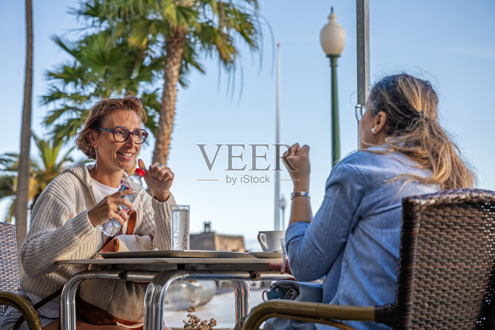 两位女性在户外咖啡馆交谈 - 连接的瞬间照片摄影图片